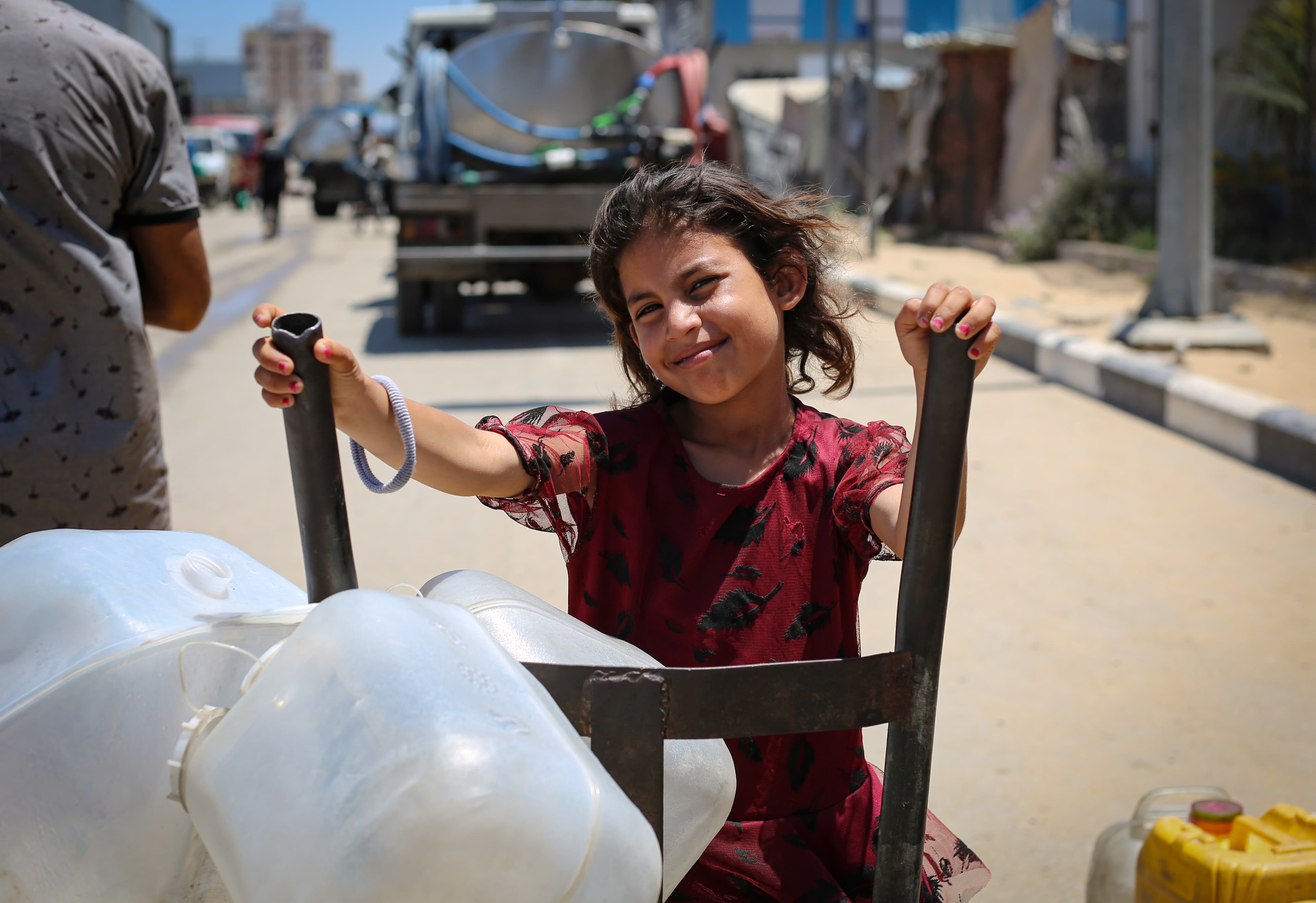 Flicka med vattendunkar - WASH - Gaza 2025