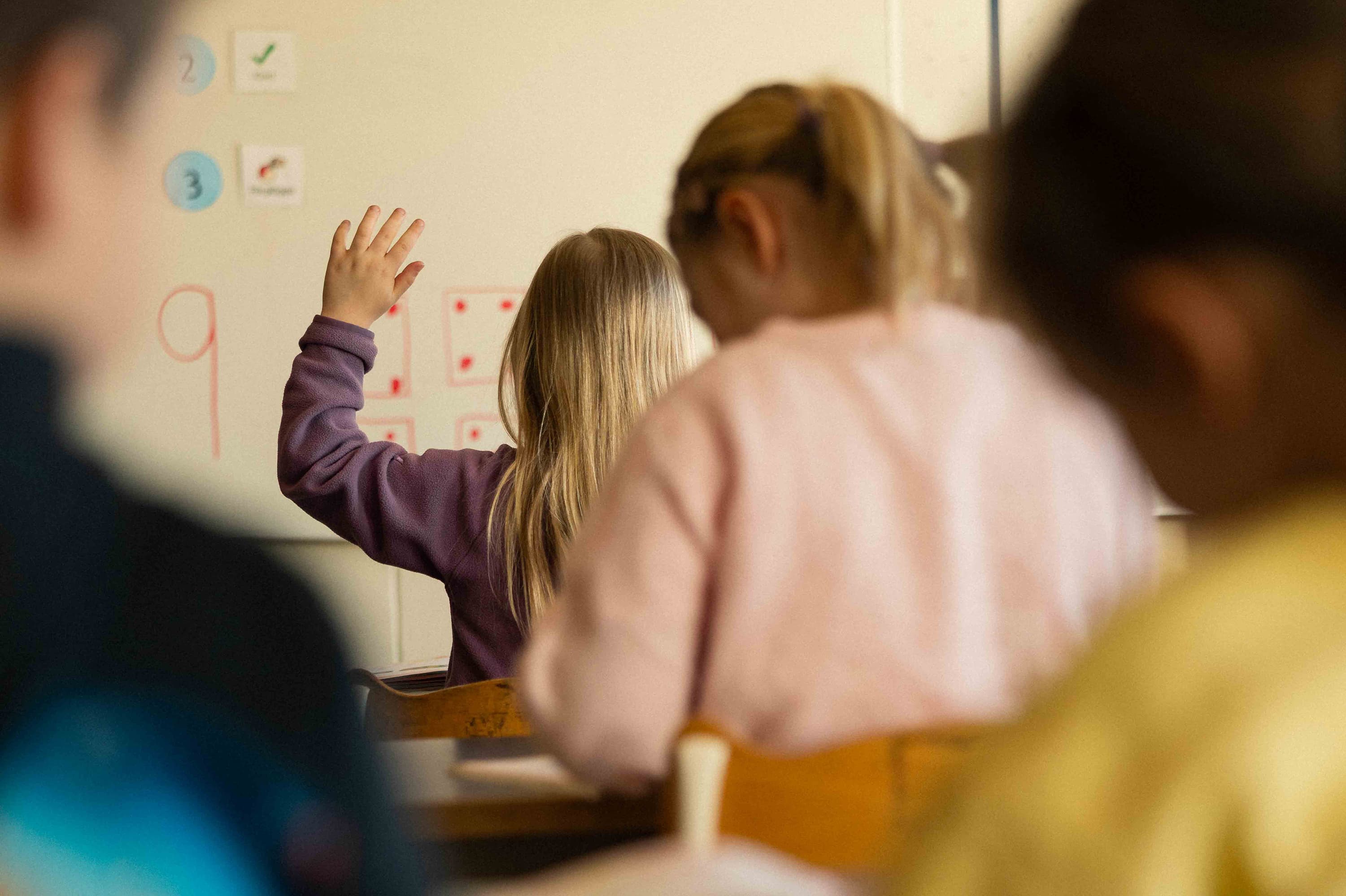 Barn räcker upp handen i klassrum - Sverige 2026