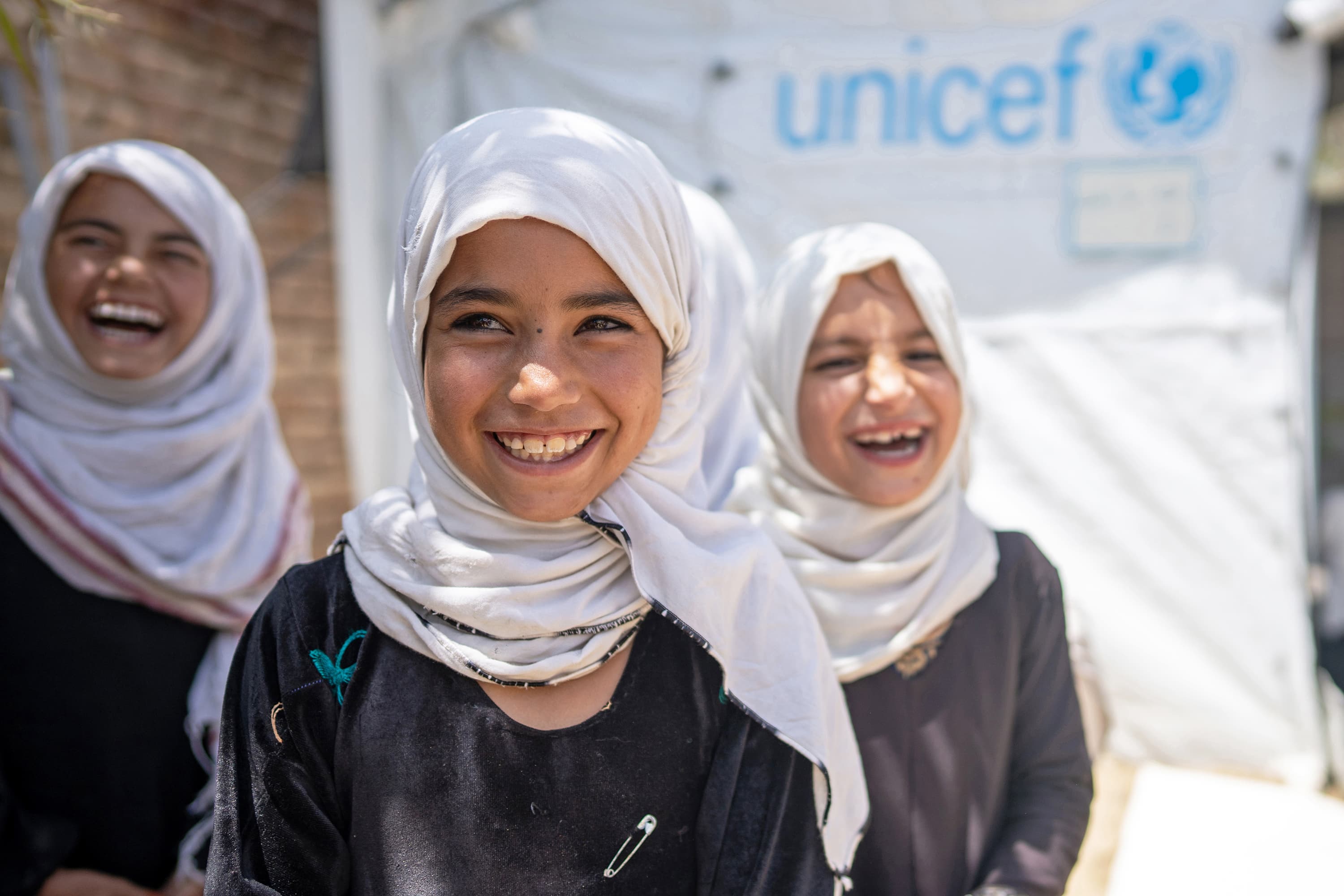 Glada flickor framför skola - Afghanistan 2024