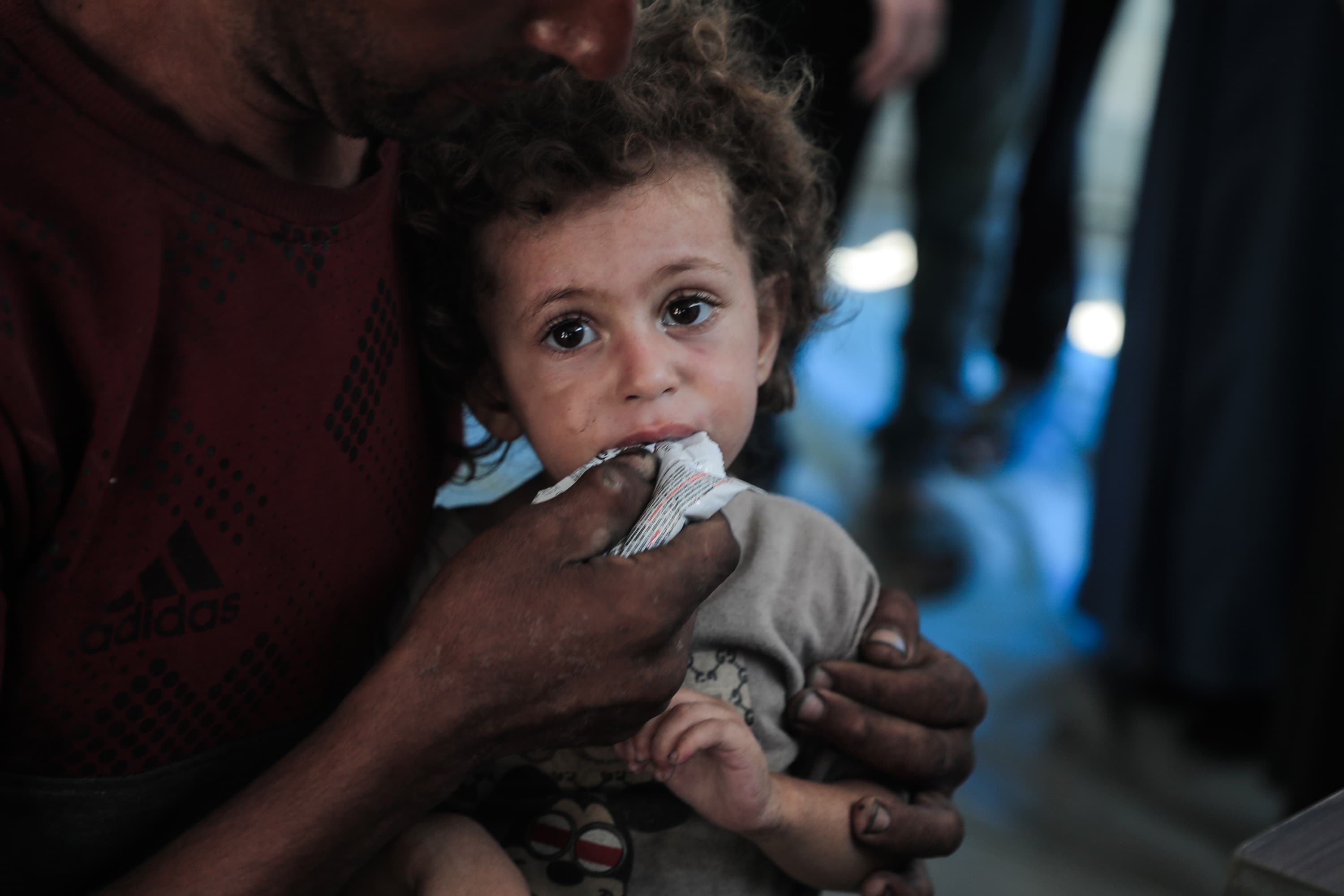 Barn med nötkräm - i vuxens famn - Gaza 2025